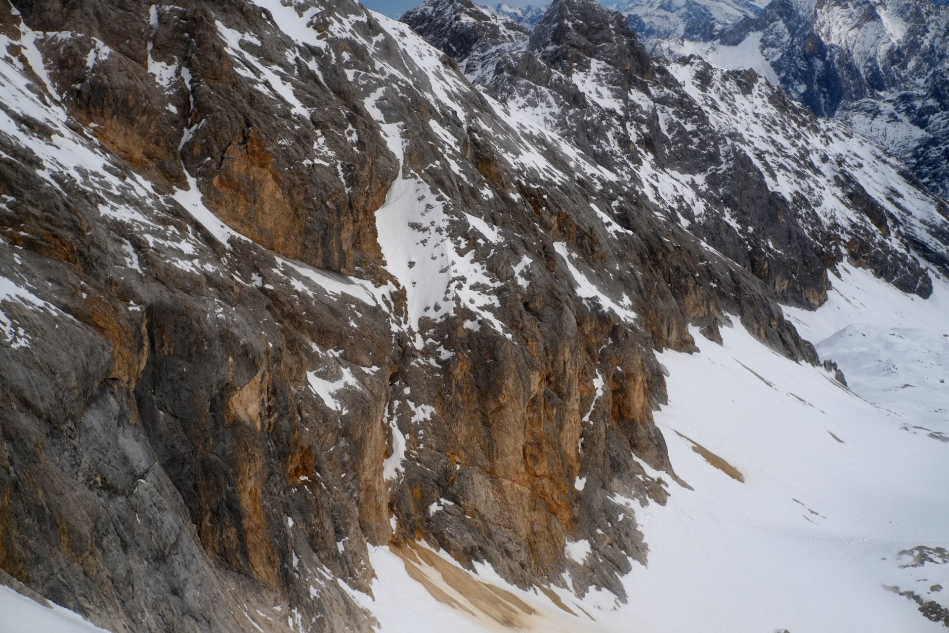 A photo of a grey-brown rocky cliff taken at approximately the same height level midair while in a cable car.