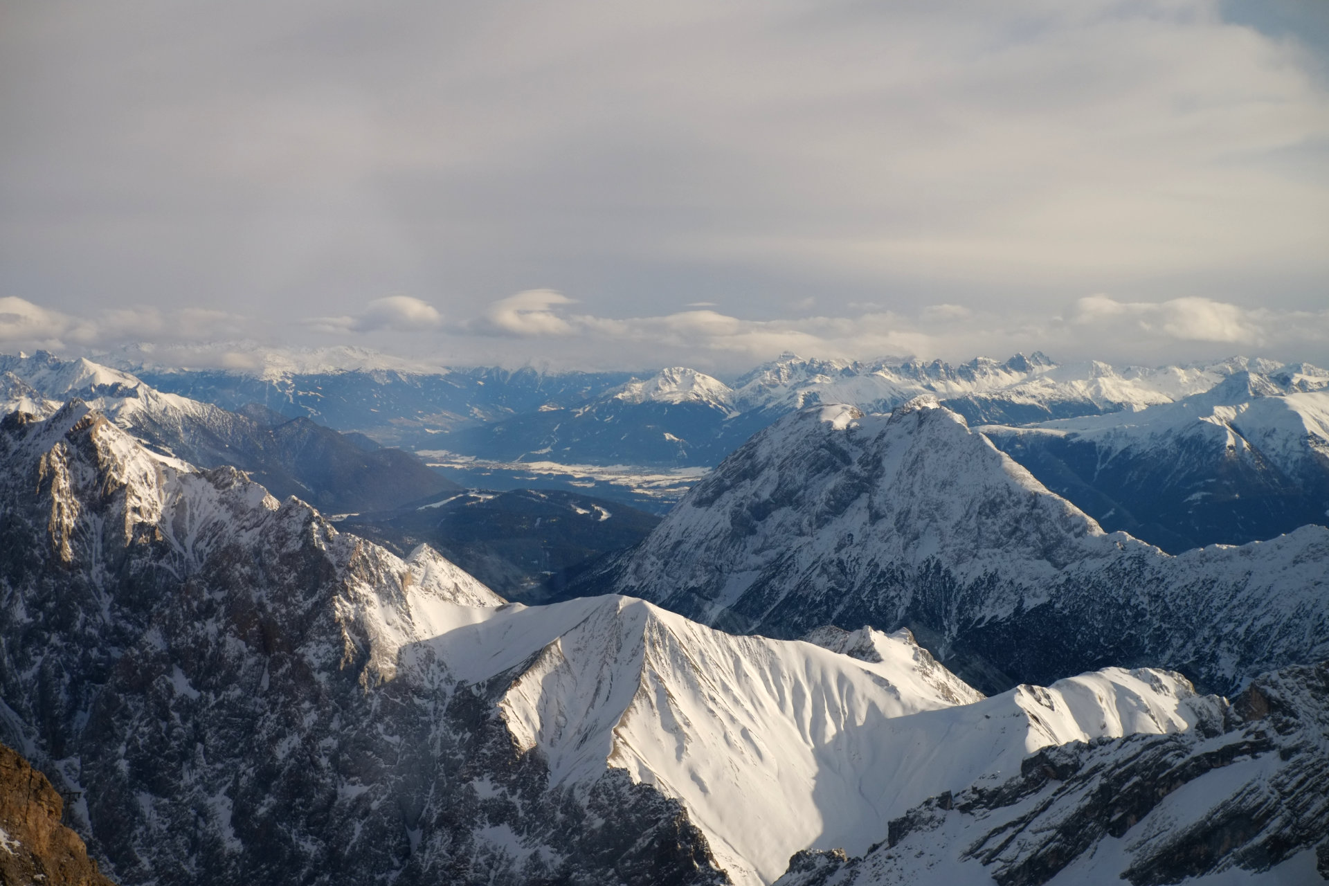 A photo of snowy mountain peaks illuminated by the low evening sun.