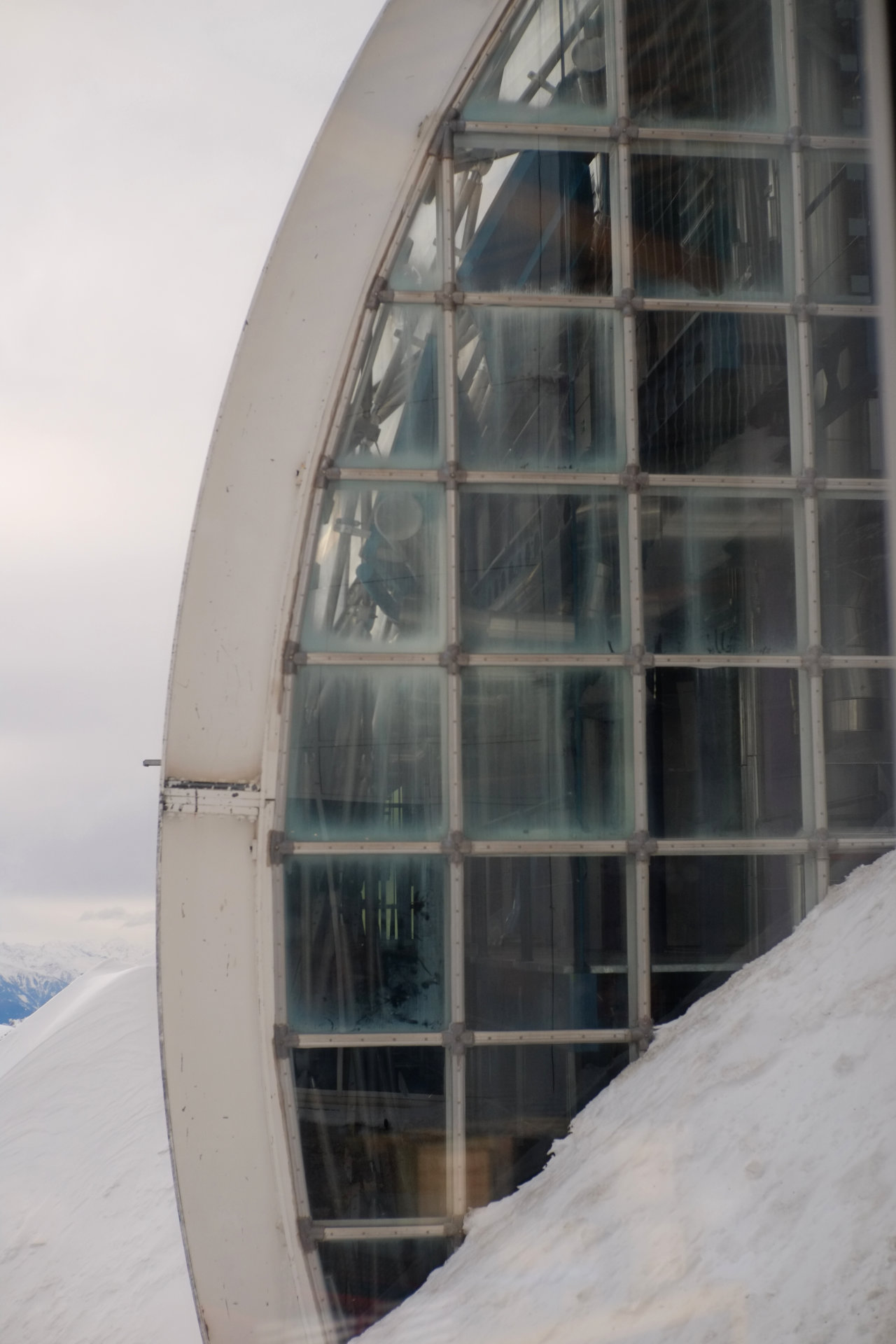 A photo of a glass wall with white metal grid and round border.