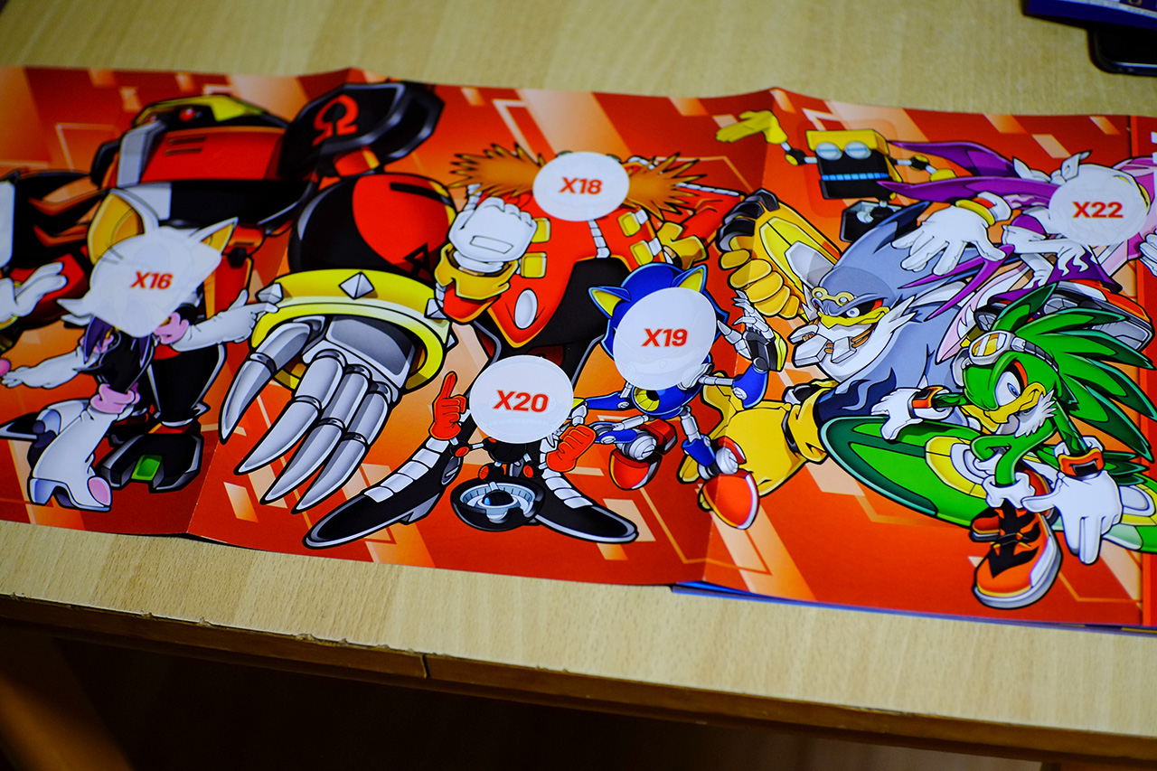 A photo of a 3 page wide poster from Sonic the Hedgehog sticker album, featuring character art of Team Dark, Babylon Rogues, Doctor Eggman, Metal Sonic, Cubot — all drawn in the style of Sonic Adventure 2 promotional art.