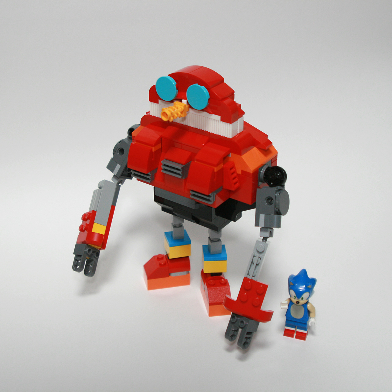 A photo of an Egg Pawn from Sonic Heroes (2003) built with LEGO, with a Sonic the Hedgehog LEGO minifigure standing next to it.