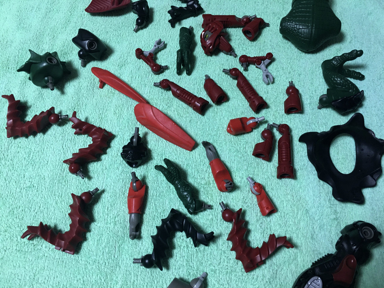 A photo of various Lego Galidor parts drying on a light green towel after a wash.